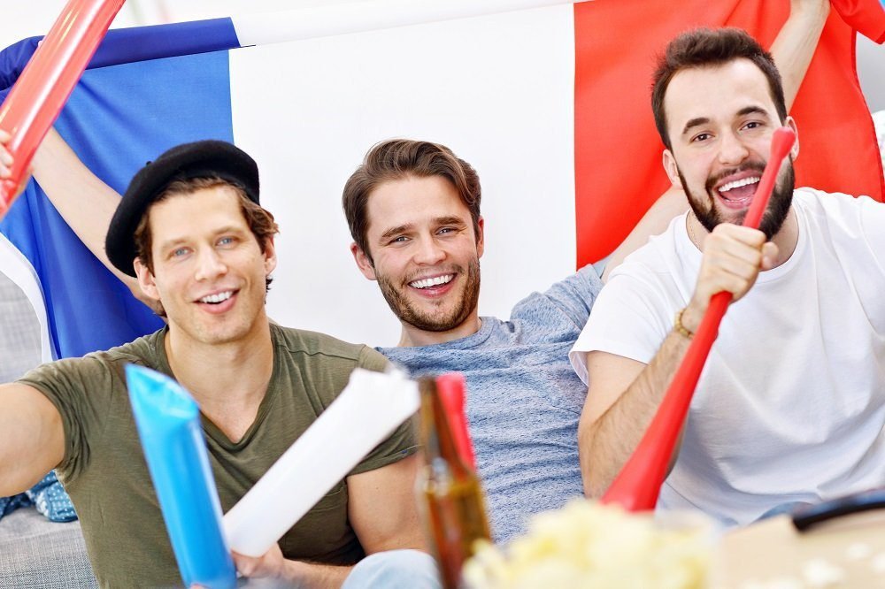 happy male friends cheering watching sports tv